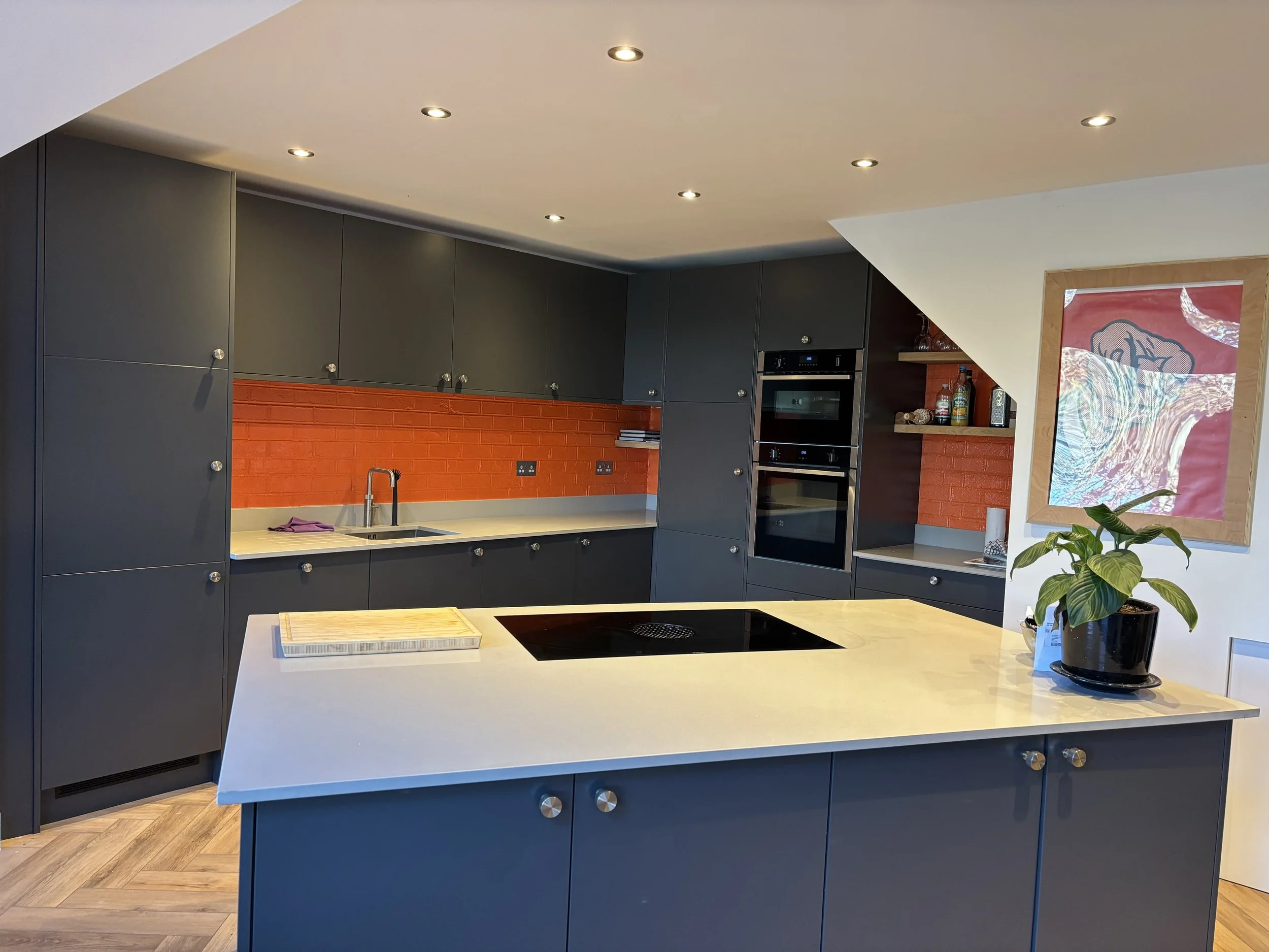 Kitxchen with red splashback and blue units.