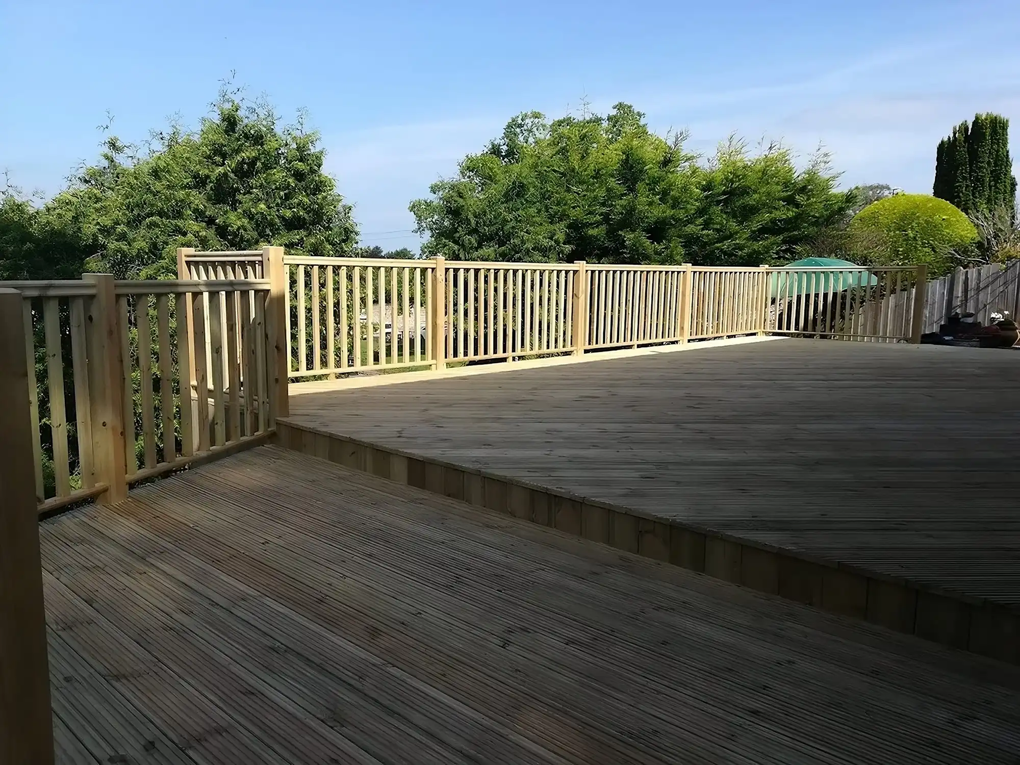 Wooden fence around wooden decking.