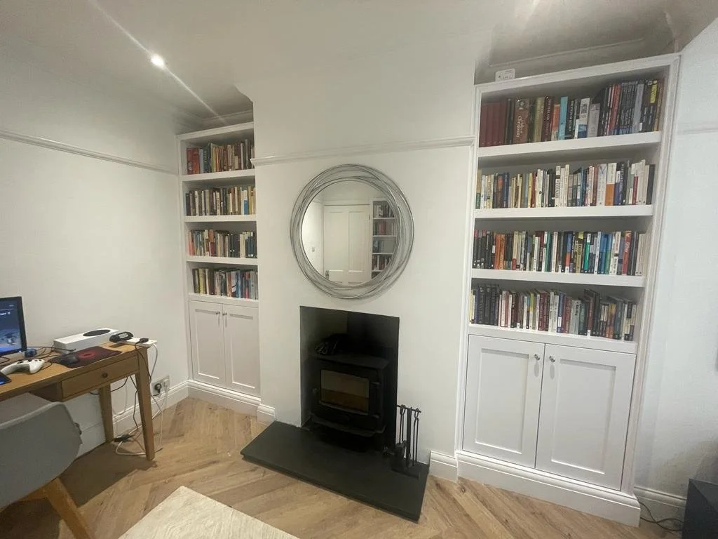 Two bookcases with a fireplace inbetween.