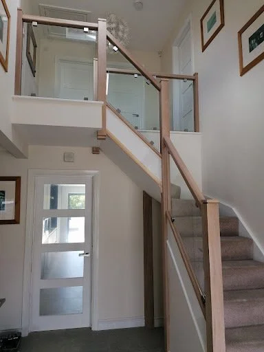 curved wooden staircase with glass balustrades.